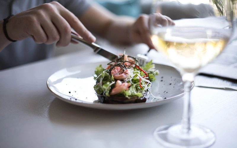 Person-enjoying-a-meal-alone-with-a-glass-of-wine