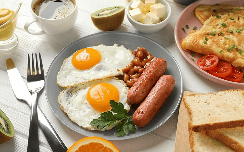 Breakfast with fried eggs, sausages, beans and toast